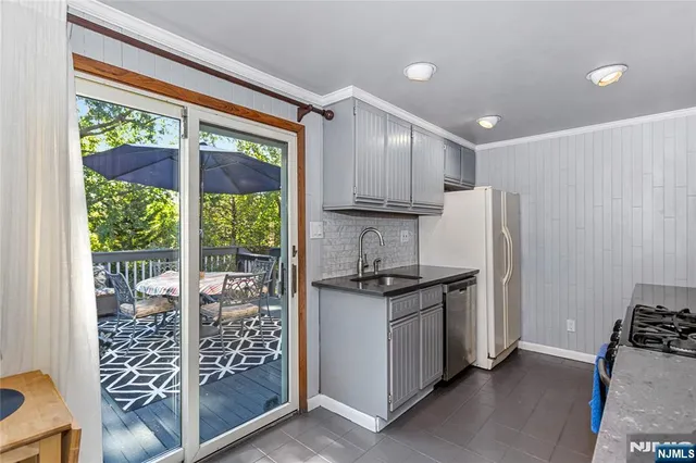 a kitchen with stainless steel appliances granite countertop a stove a refrigerator and a sink with wooden cabinets