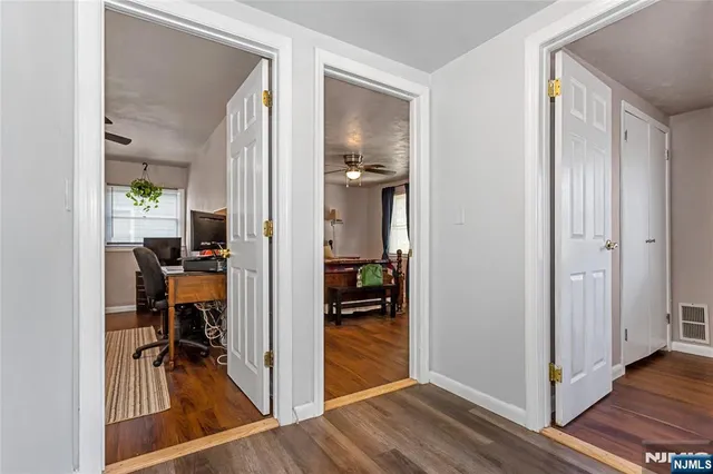 a view of a hallway with dining room and wooden floor