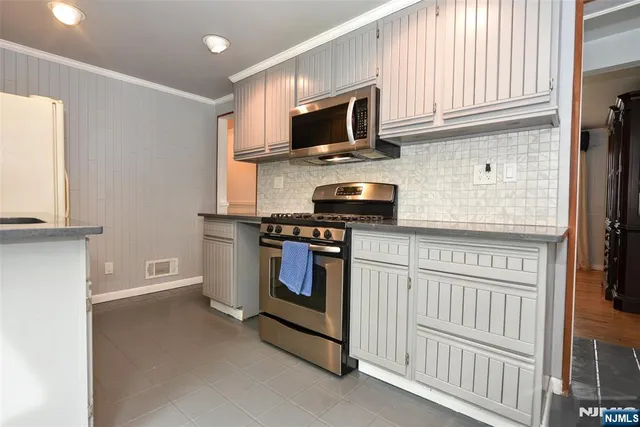 a kitchen with stainless steel appliances a stove microwave and cabinets