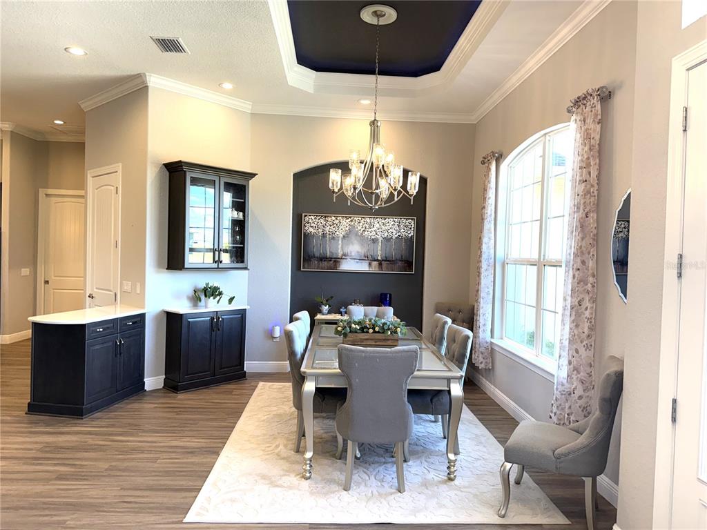 17898 Southwest 72nd Street Road Dunnellon, FL 34432 - Photo 14 of 85 a dining room with wooden floor and kitchen view