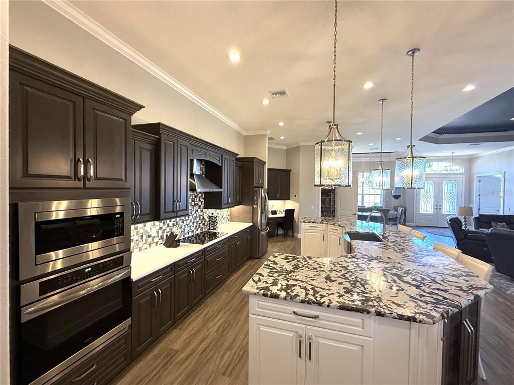 17898 Southwest 72nd Street Road Dunnellon, FL 34432 - Photo 19 of 85 a kitchen with kitchen island granite countertop wooden cabinets and a stove