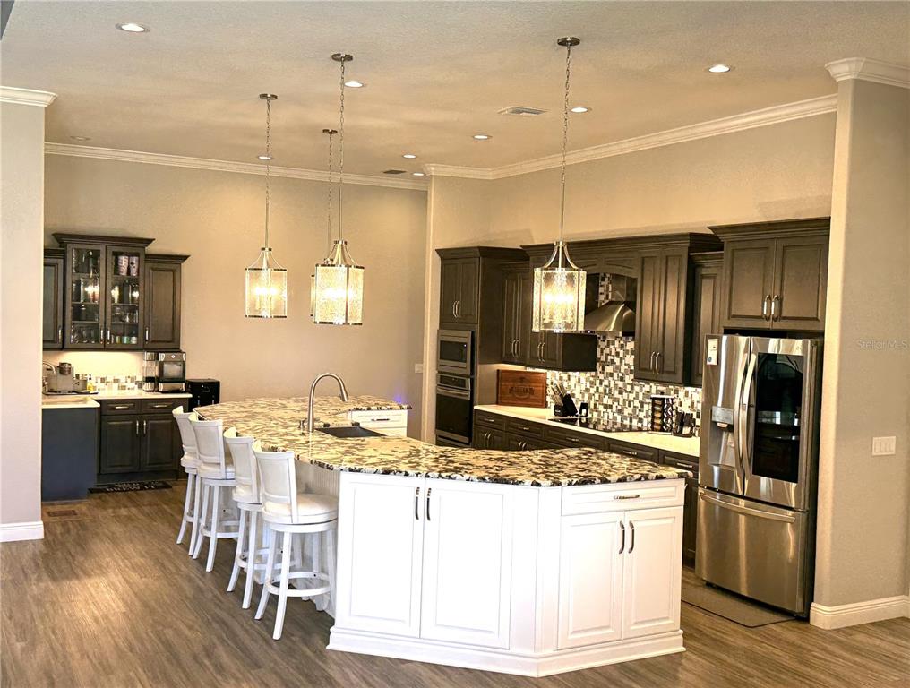 17898 Southwest 72nd Street Road Dunnellon, FL 34432 - Photo 22 of 85 a kitchen with stainless steel appliances kitchen island granite countertop a sink refrigerator and cabinets
