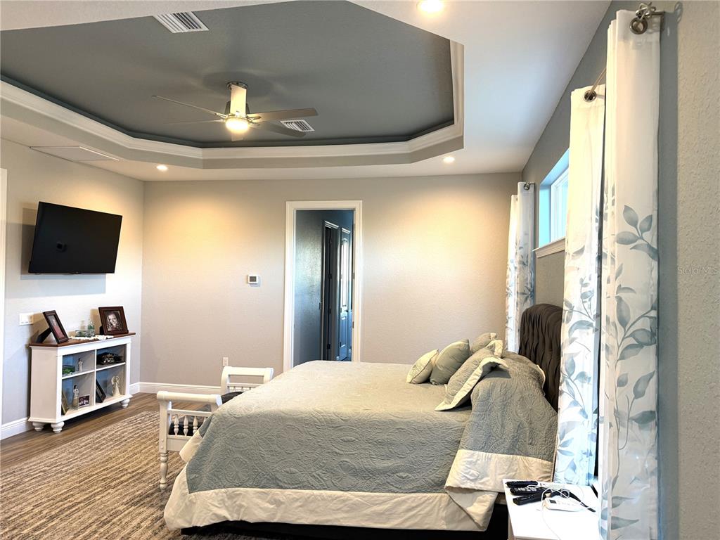 17898 Southwest 72nd Street Road Dunnellon, FL 34432 - Photo 35 of 85 a bedroom with a bed and a flat tv screen on dresser