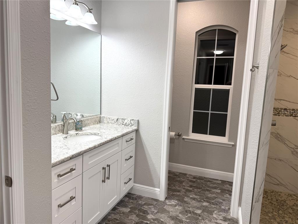 17898 Southwest 72nd Street Road Dunnellon, FL 34432 - Photo 40 of 85 a bathroom with a granite countertop sink and a mirror