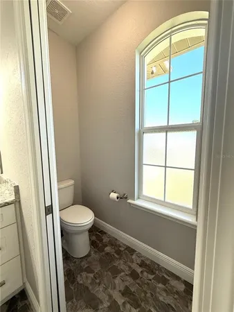 a view of a large white kitchen with a large window