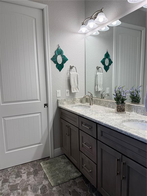 17898 Southwest 72nd Street Road Dunnellon, FL 34432 - Photo 50 of 85 a bathroom with a granite countertop sink a mirror and a potted plant