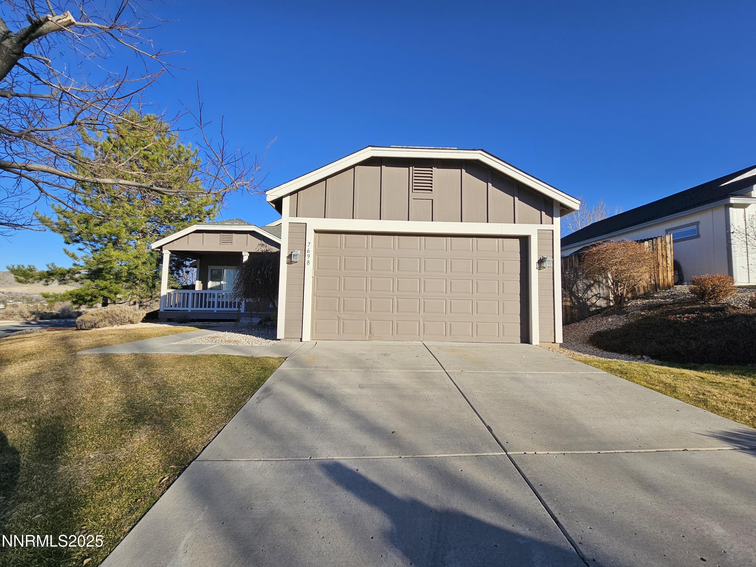 7698 Quarry Rock Court Reno, NV 89506 - Photo 2 of 33 a front view of a house with a yard and garage