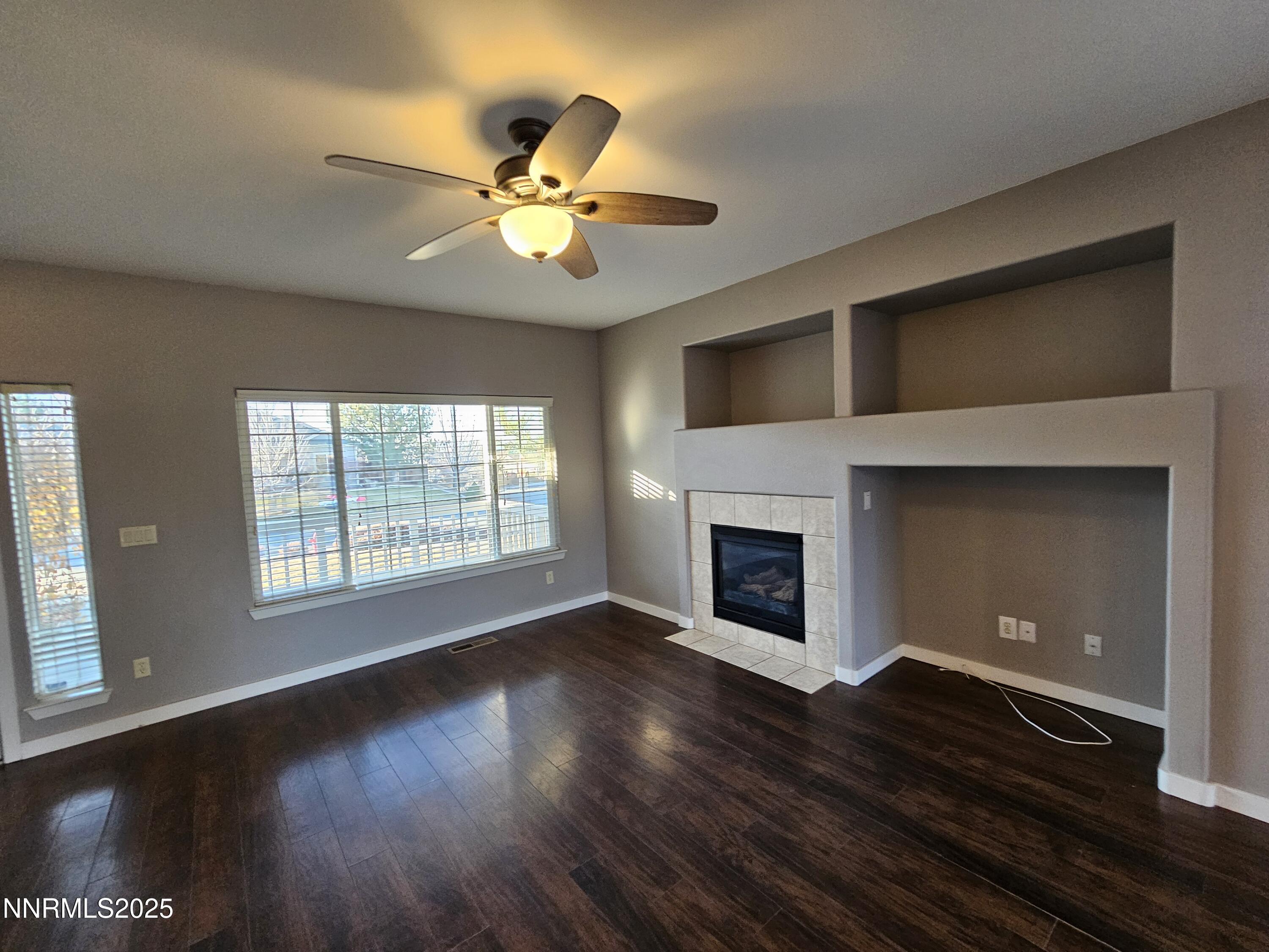 7698 Quarry Rock Court Reno, NV 89506 - Photo 4 of 33 a view of an empty room with wooden floor fireplace and a window