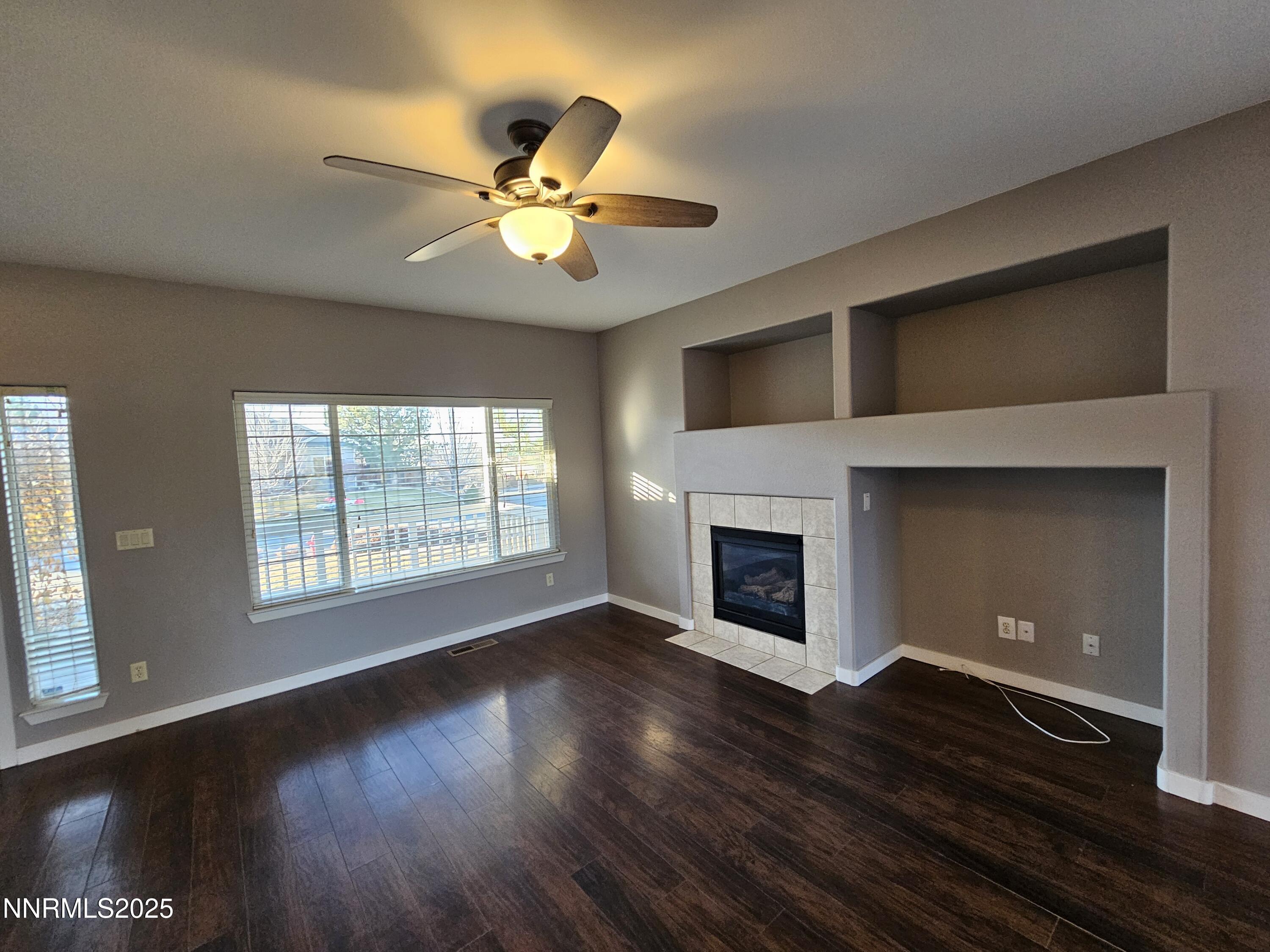 7698 Quarry Rock Court Reno, NV 89506 - Photo 5 of 33 a view of an empty room with wooden floor fireplace and a window