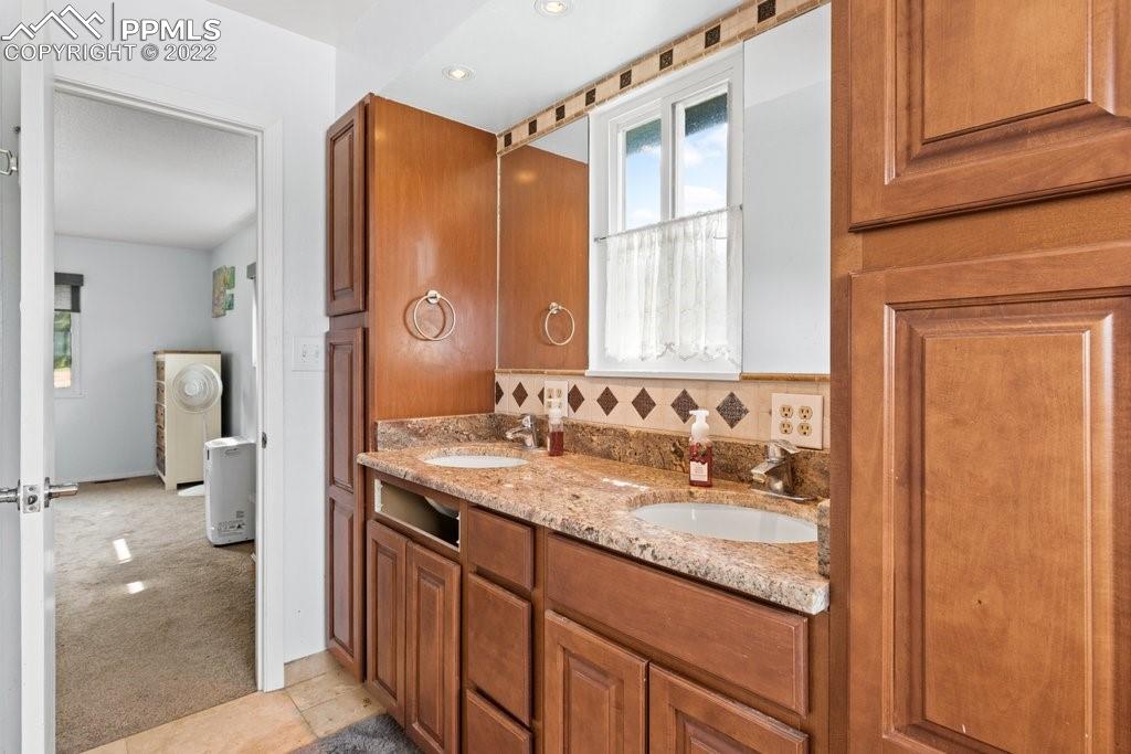 1847 County Road, Unit 671 Rye, CO 81069 - Photo 20 of 42 a en suite bathroom with a granite countertop sink and a mirror