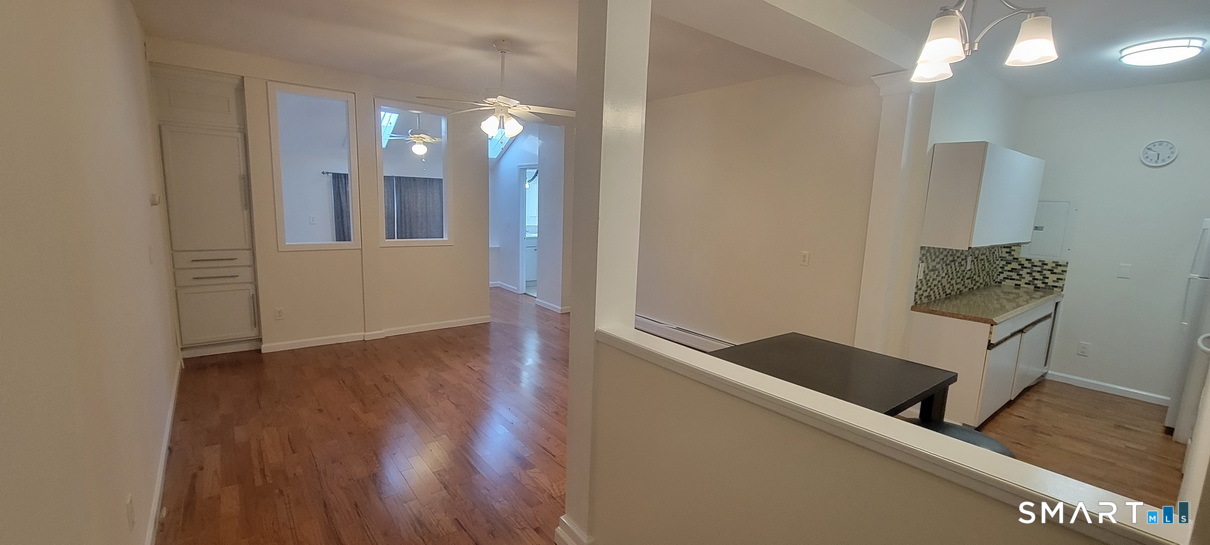 109 Wooster Street, Unit F Bethel, CT 06801 - Photo 3 of 11 a view of a hallway with wooden floor and staircase