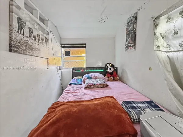 a bedroom with a bed and painting on the wall