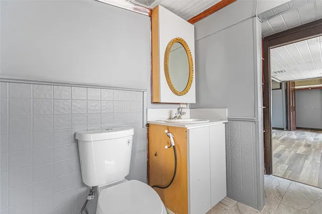 a bathroom with a toilet sink and mirror