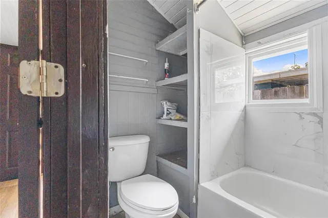 a bathroom with a toilet and a shower