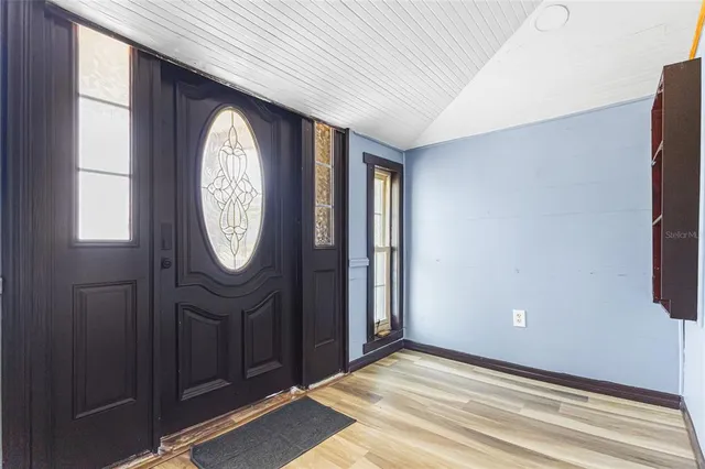 a view of a hallway with wooden floor and a window