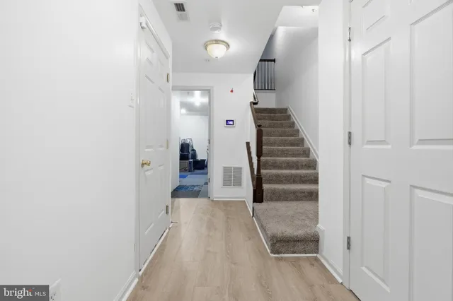a view of a hallway with wooden floor and entryway