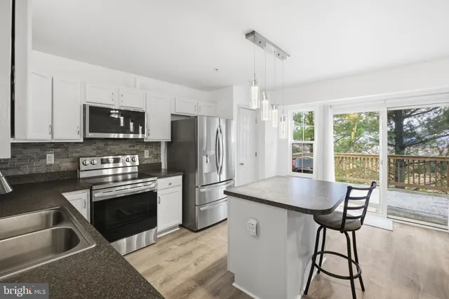 a kitchen with stainless steel appliances granite countertop a stove a refrigerator and a microwave