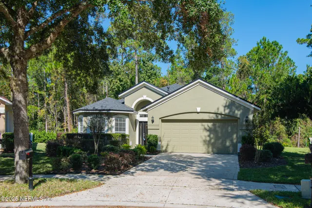 a front view of a house with a yard and trees