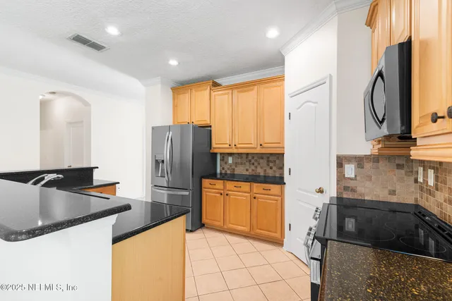 a kitchen with granite countertop a refrigerator and a sink