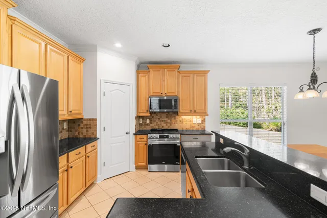 a kitchen with granite countertop a refrigerator and a sink