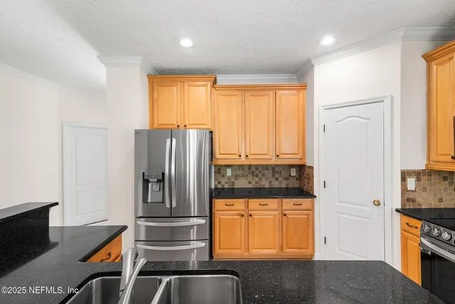 a kitchen with stainless steel appliances granite countertop a refrigerator and a stove top oven