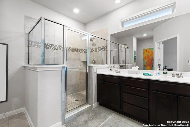 a bathroom with a double vanity sink and mirror with shower