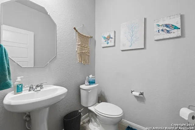 a bathroom with a toilet sink and mirror