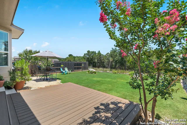 a view of a backyard with table and chairs under an umbrella