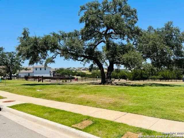 a view of a swimming pool in a yard with lawn chairs