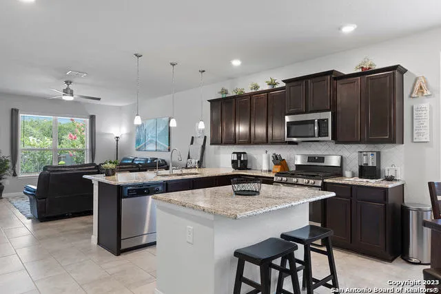 a kitchen with a stove a sink a microwave a dining table and chairs