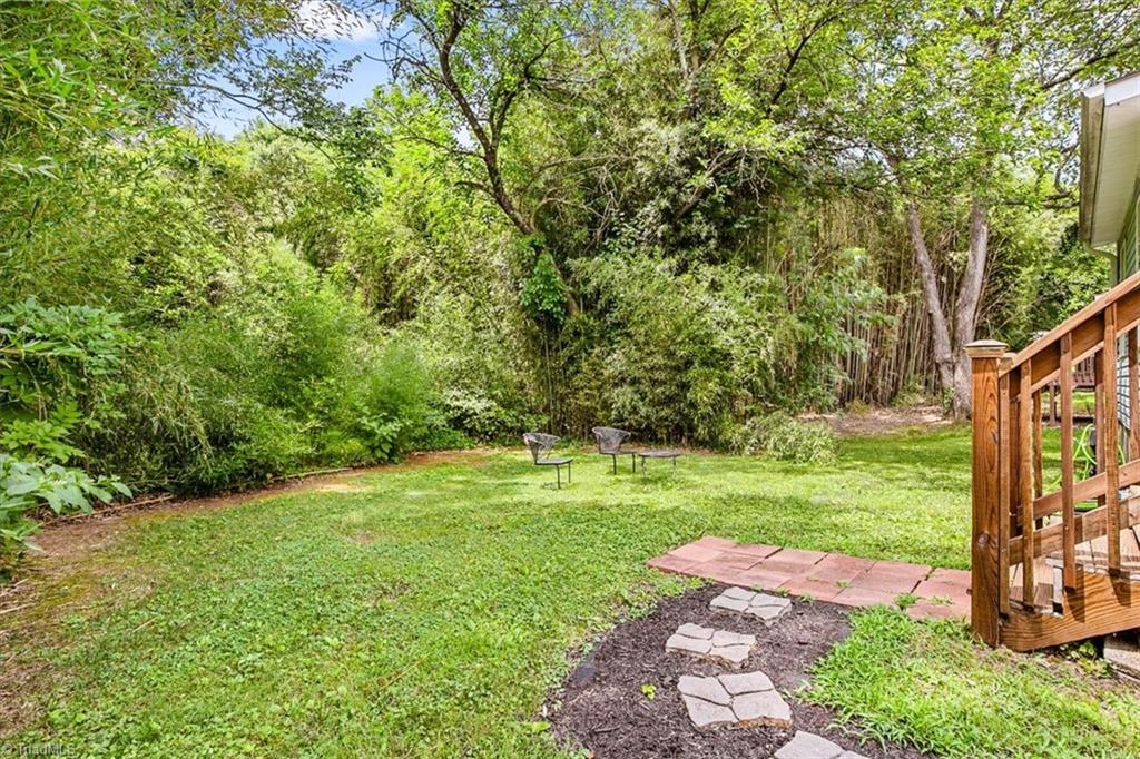 226 Friendly Avenue High Point, NC 27260 - Photo 36 of 38 The backyard at 226 Friendly Avenue backs up to mature trees and greenery, offering a private, shaded retreat on this 0.18 acre High Point lot.