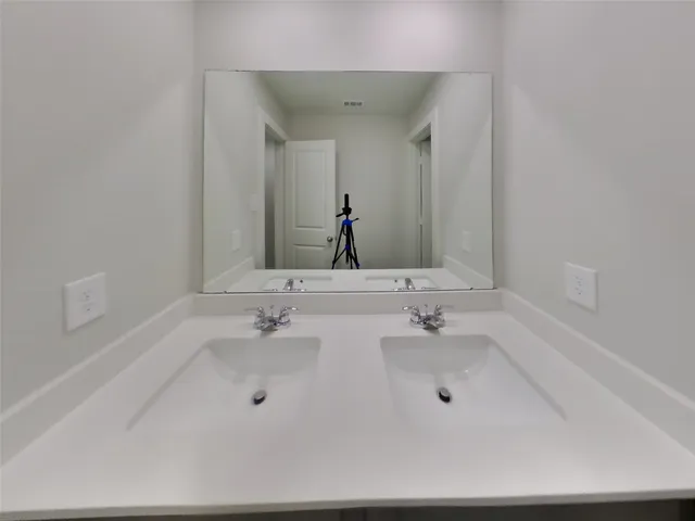 a bathroom with double vanity sink and a mirror