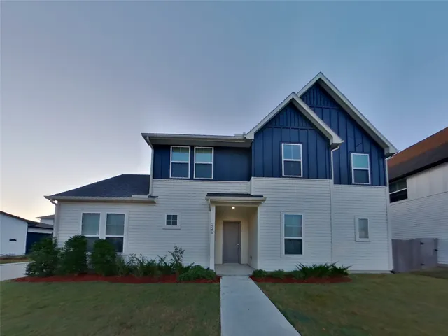 a front view of a house with a garden and plants