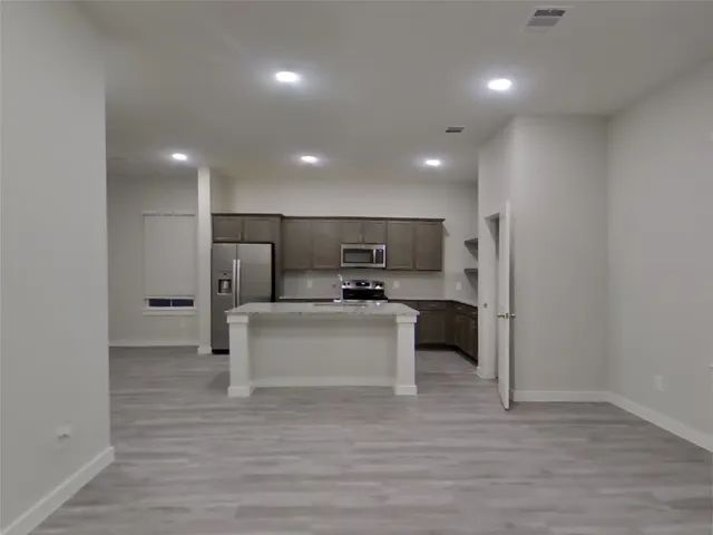 a view of kitchen with refrigerator microwave and stove