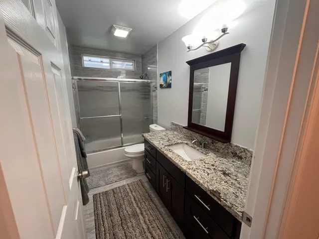 a bathroom with a granite countertop sink and a mirror