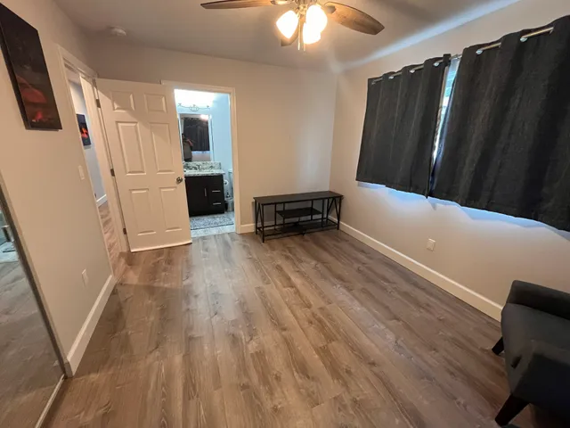 a view of a livingroom with wooden floor and stairs