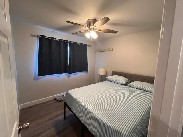 a bedroom with a bed and a ceiling fan