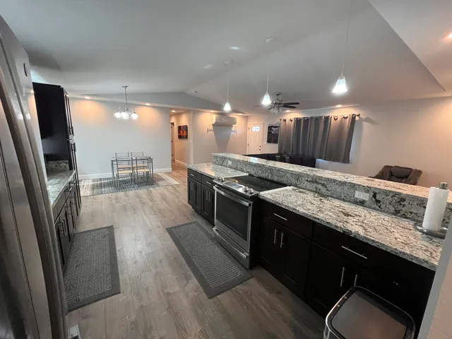 a large kitchen with stainless steel appliances granite countertop a stove a sink and a refrigerator