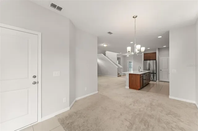 a view of a room with kitchen island stainless steel appliances wooden floor and living room view