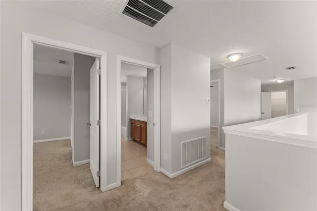 a view of hallway with stainless steel appliances wooden floor and living room view