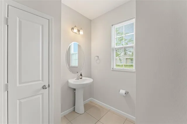 a bathroom with a sink mirror and window