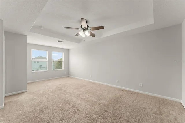 an empty room with windows and fan