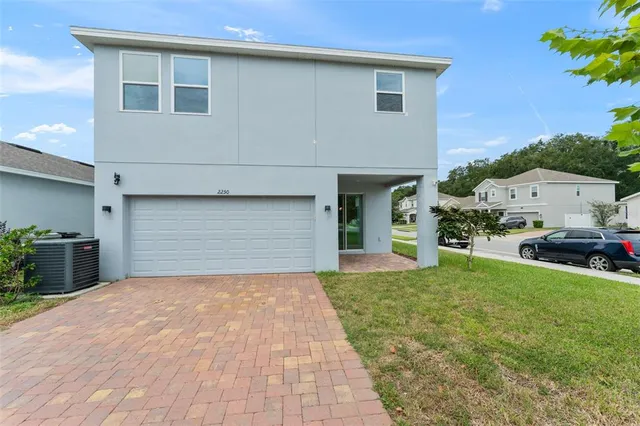 a front view of a house with a yard and trees