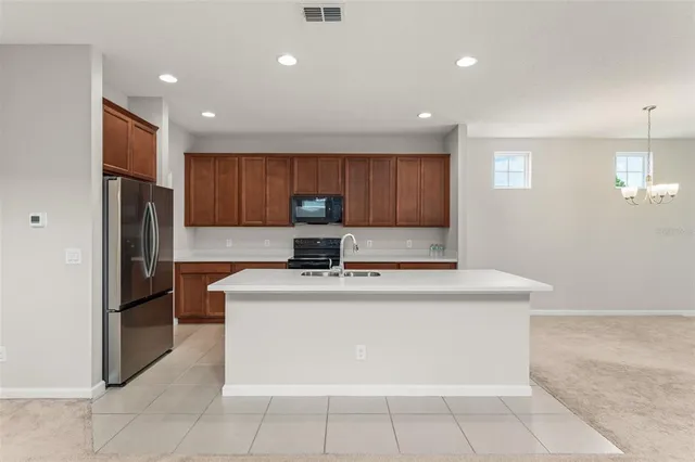 a kitchen with stainless steel appliances granite countertop a stove a refrigerator a sink and a microwave