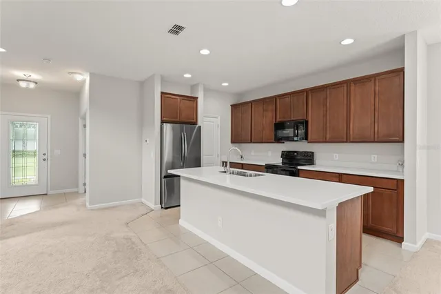 a kitchen with stainless steel appliances granite countertop a refrigerator stove microwave and sink