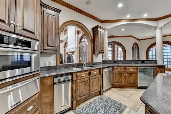 a kitchen with granite countertop a stove sink and cabinets