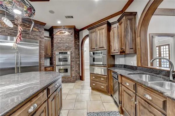 a kitchen with a sink a counter space appliances and cabinets