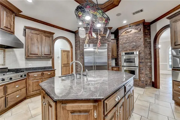 a kitchen with stainless steel appliances granite countertop a sink a stove and cabinets