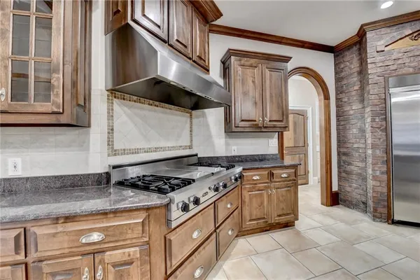 a kitchen with stainless steel appliances kitchen island granite countertop a refrigerator and cabinets