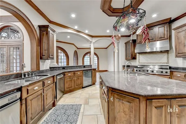 a kitchen with stainless steel appliances granite countertop a sink a stove and a refrigerator